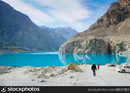 Men walking to ride a boat at the Attabad lake which has turquoise color. Gojal Hunza, Gilgit-Baltistan, Pakistan.