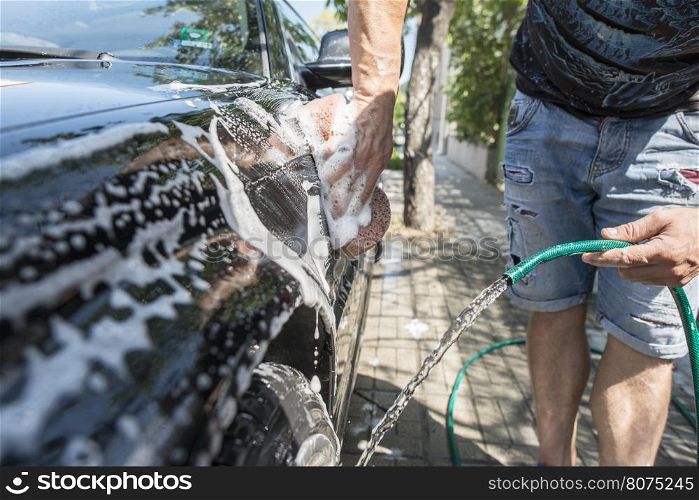 Men wash his car. Close up hose