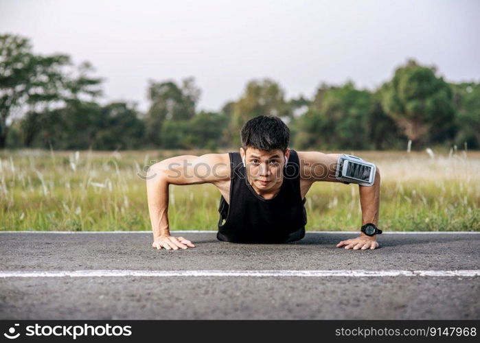 Men wear black shirts with muscles push up on the street.