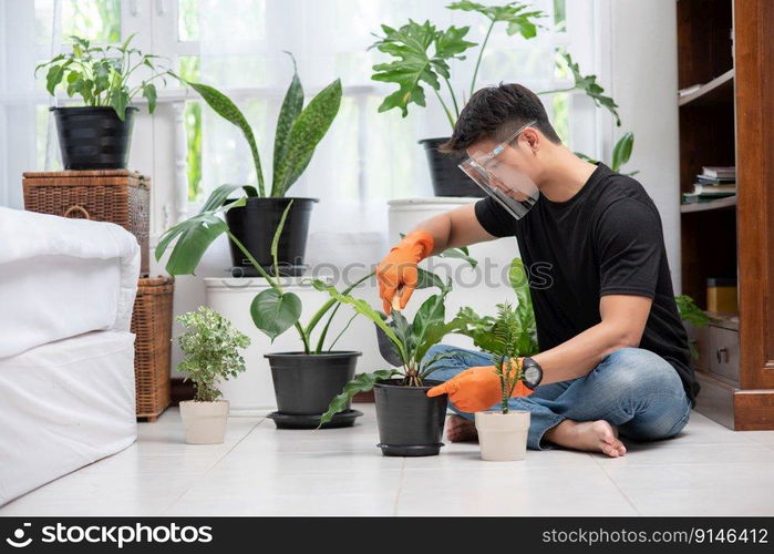 Men wearing orange gloves and planting trees indoors.