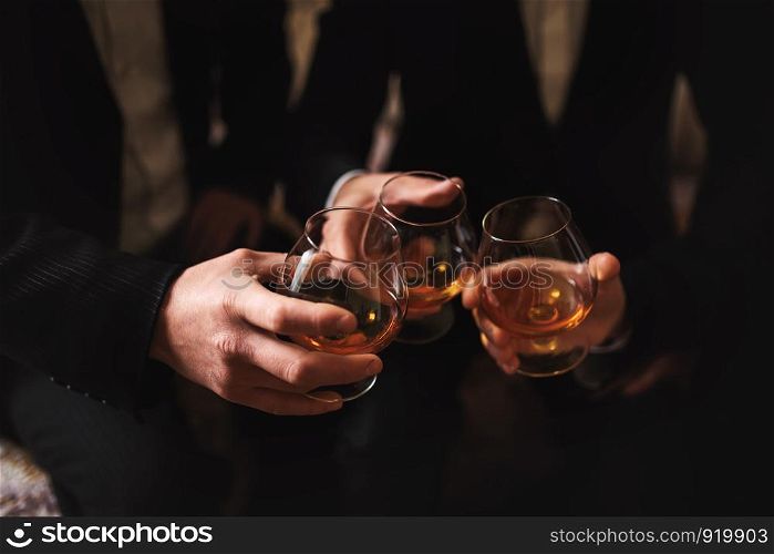 men with a friend. hold in the hands of glasses of whiskey. close up. Business meeting. Men hold glasses of whiskey. Men's Party. Hand with a drink of alcohol