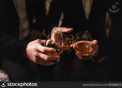 men with a friend. hold in the hands of glasses of whiskey. close up. Business meeting. Men hold glasses of whiskey. Men's Party. Hand with a drink of alcohol