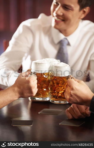 Men with big mugs of beer close up