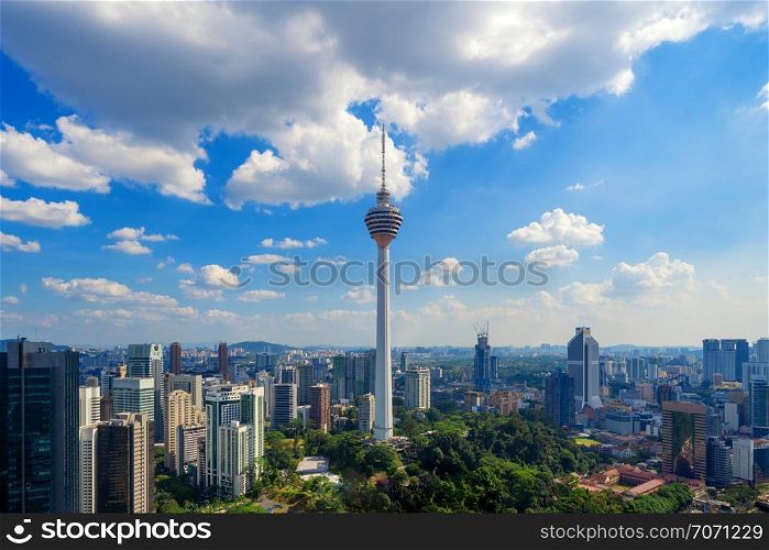 Menara Kuala Lumpur Tower with clouds sky. Aerial view of Kuala Lumpur Downtown, Malaysia. Financial district and business centers in urban city in Asia. Skyscraper and high-rise buildings at noon.