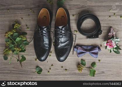Mens items clothing decoration for the holiday.. Belt, tie, shoes and a boutonniere on the table 9694.