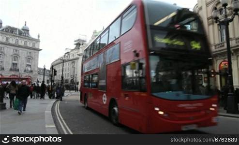 Menschen an einer Strasse in London. Ein Doppeldeckerbus fShrt vorbei.