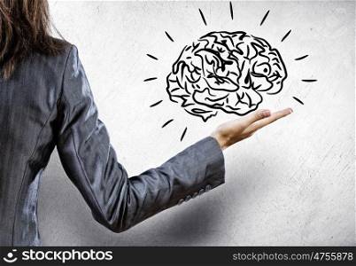 Mental ability. Rear view of businesswoman holding human brain in palm