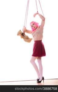 Mental disorder concept. Young woman girl stylized like marionette puppet on string with teddy bear toy isolated on white background