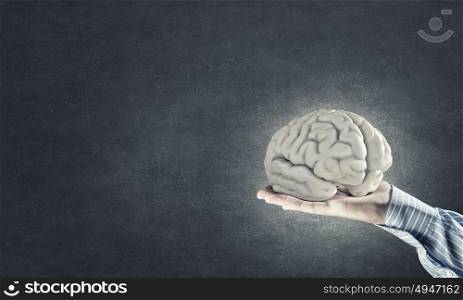 Mental health. Close up of businessman hand holding brain