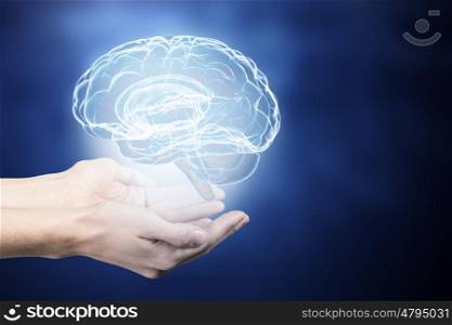 Mental health concept. Close up of human hand holding brain