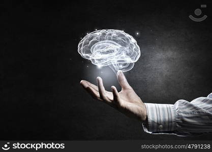 Mental health concept. Close up of human hand holding brain symbiol