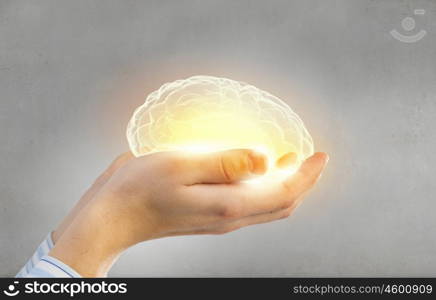 Mental health protection and care. Close up of human hand holding brain
