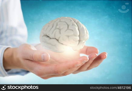 Mental health protection and care. Close up of human hand holding brain