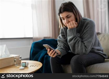 mental health, psychological help and depression concept - stressed woman with medicine pills on table holding smartphone at home. stressed woman with medicine and phone at home