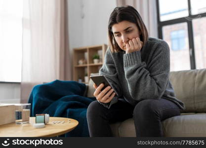 mental health, psychological help and depression concept - stressed woman with medicine pills on table holding smartphone at home. stressed woman with medicine and phone at home