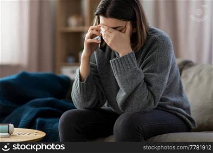 mental health, psychological help and depression concept - stressed woman with sedative medicine on table calling on phone at home. stressed woman with medicine calling on phone