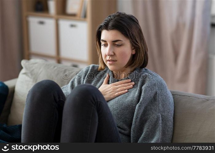 mental health, psychological problem and depression concept - sad woman having trouble breathing or panic attack at home. sad woman having panic attack at home