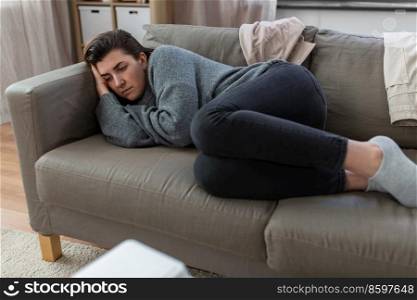 mental health, psychological problem and depression concept - stressed woman lying on sofa at home. depressed woman lying on sofa at home