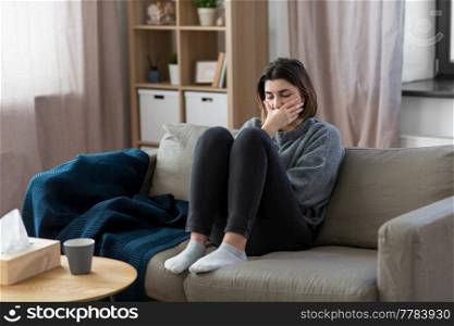 mental health, psychological problem and depression concept - stressed woman sitting on sofa at home. stressed woman sitting on sofa at home