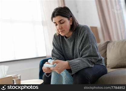 mental health, stress and depression - sad woman popping bubble wrap at home. sad woman popping bubble wrap at home