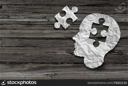 Mental health symbol Puzzle and head brain concept as a human face profile made from crumpled white paper with a jigsaw piece cut out on a rustic old double page spread horizontal wood background.