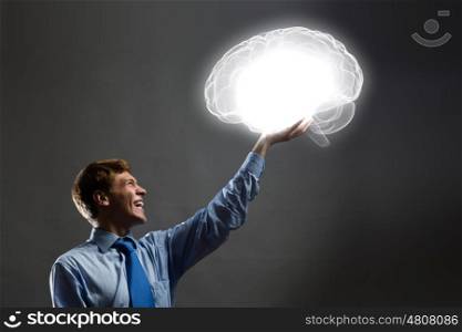 Mental health. Young man holding 3d image of human brain in hand