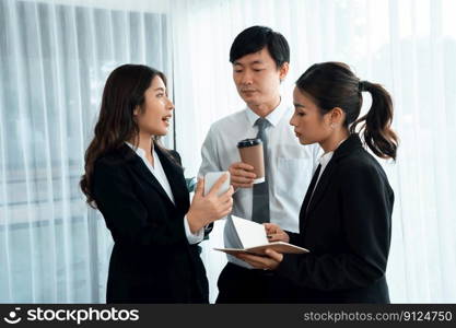 Mentor, manager with coffee advice younger colleagues in workplace. Businesspeople discussing or planning financial project strategy, talking together for harmony and strong teamwork in office concept. Manager with coffee advice colleagues as concept of harmony in office.