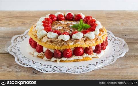 Meringue cake with strawberry yogurt on rustic wood.. Meringue cake with strawberry yogurt on rustic wood