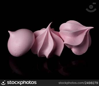 Meringues isolated on black background with reflection.