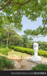 Merlion statue in park. in park tree near and top mountain.