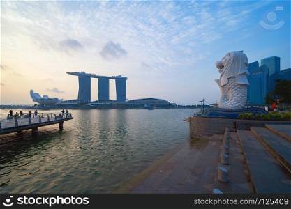 Merlion with skyscraper buildings in Singapore City at noon. Financial district in downtown with business centers in technology smart urban city in Asia.