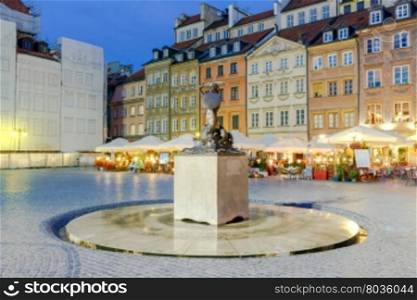 Mermaid statue, symbol of the city of Warsaw. The Old Town Square at night. Poland.