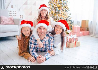 Merry Christmas and Happy Holidays. Family of four on Christmas at home. Happy young family with kids holding christmas presents