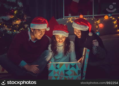 Merry Christmas and Happy Holidays.Happy family opens the magic box with light in dark on Christmas day at home.Christmas family .