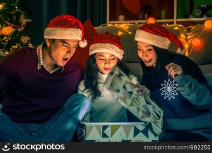 Merry Christmas and Happy Holidays.Happy family opens the magic box with light in dark on Christmas day at home.Christmas family .