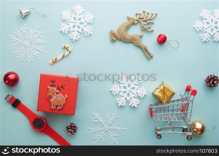 Merry Christmas and Happy New Year. Foam cutter of snowflake, golden reindeer, gift box and shopping cart on pastel color paper