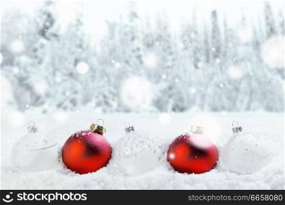 Merry Christmas and Happy New Year greeting card with balls in a row and falling snow . Background with copy space .. Christmas balls and snow