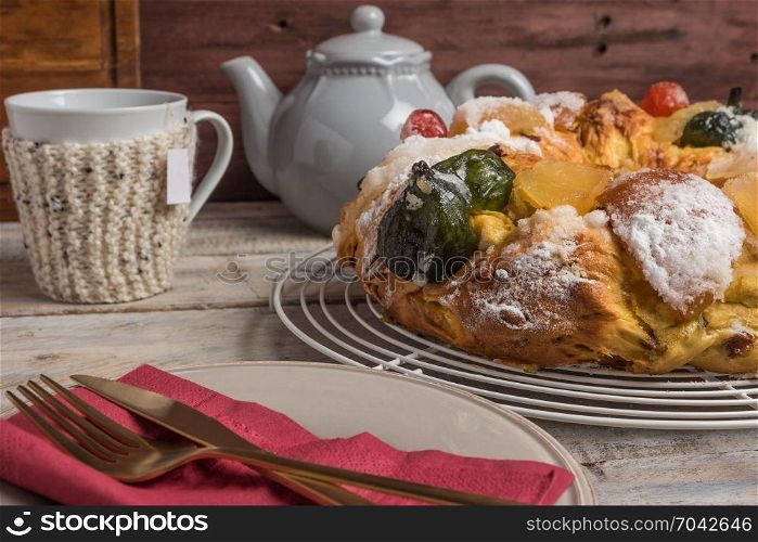 Merry Christmas cake with nuts - Bolo Rei is a traditional Xmas cake with fruits raisins nut and icing on wooden table.