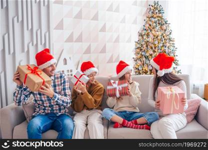 Merry Christmas. Family of four with gifts on Christmas at home. Happy young family with kids holding christmas presents