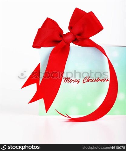 Merry Christmas greeting card, beautiful blue and green postcard with red ribbon bow over white background, wishing happy holidays