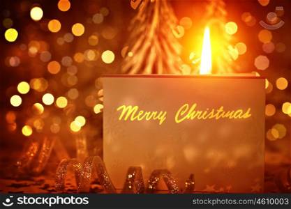 Merry Christmas greeting card on golden glowing festive background, warm candle light, shiny glitters, happy holiday concept