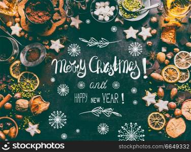 Merry Christmas greeting card with text lettering , spices, chocolate and cookies on dark background with sweet food ingredients  nuts, dried fruits, broken chocolate, cookies and winter spices
