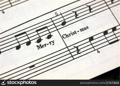 Merry Christmas text on a sheet of music.. Merry Christmas Music