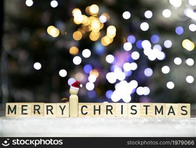 Merry Christmas text written with bokeh cbackground of Christmas tree in the snow, copy space, Holiday, Santa and xmas concept space for text. Merry Christmas text written with bokeh cbackground of Christmas tree in the snow, copy space, Holiday, Santa and xmas concept