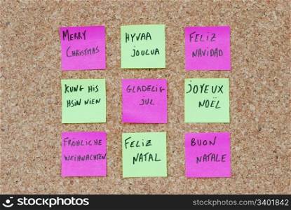 Merry Christmas tree concept in nine languages on a corkboard