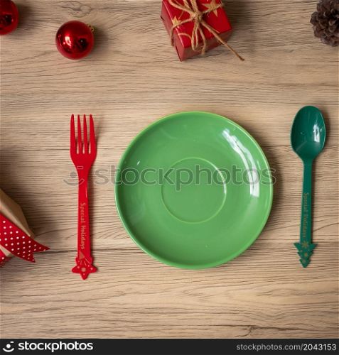 Merry Christmas with plate, fork and spoon on wood table background. Xmas, party and happy New Year concept