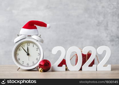 Merry Christmas with Vintage alarm clock and 2022 number on wooden table. Happy new Year, party, holiday and boxing day concept