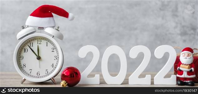 Merry Christmas with Vintage alarm clock and 2022 number on wooden table. Happy new Year, party, holiday and boxing day concept