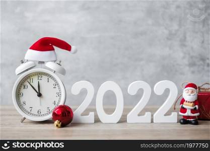 Merry Christmas with Vintage alarm clock and 2022 number on wooden table. Happy new Year, party, holiday and boxing day concept