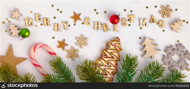 Merry Christmas written with wooden letters, cookies and Christmas decorations, flat lay